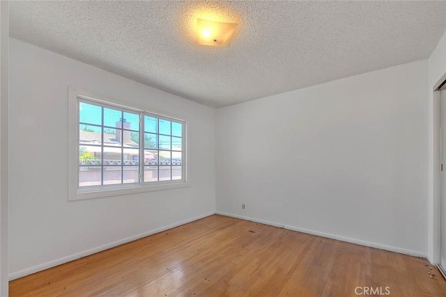 902 W Lucille Ave, West Covina, CA 91790 - unfurnished room with wood finished floors and a textured ceiling