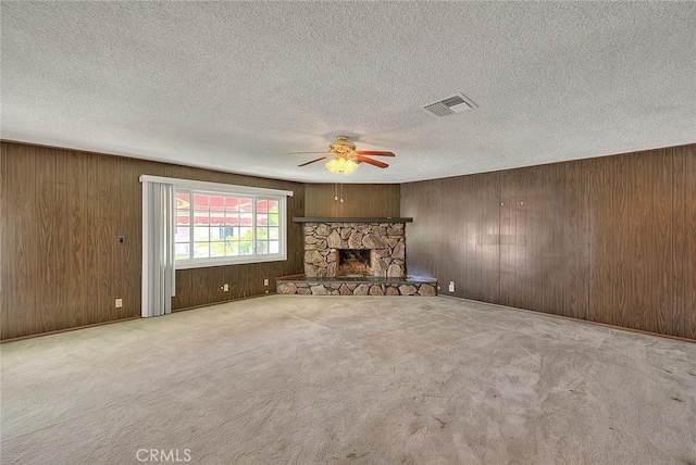 902 W Lucille Ave, West Covina, CA 91790 - unfurnished living room featuring ceiling fan, wood walls, a fireplace, a textured ceiling, and carpet