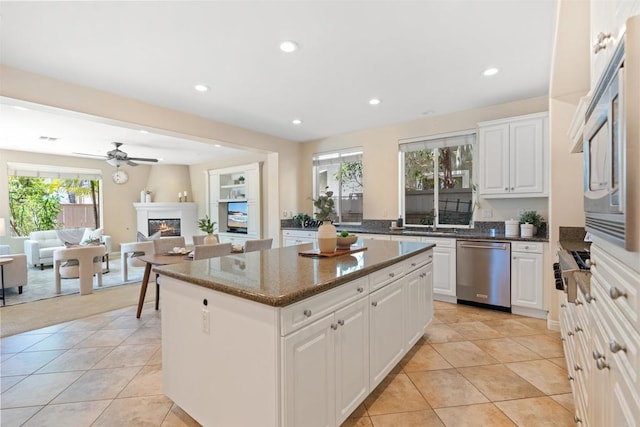 3463 Corte Fresa, Carlsbad, CA 92009 - kitchen with appliances with stainless steel finishes, a kitchen island, a glass covered fireplace, recessed lighting, and light tile patterned flooring