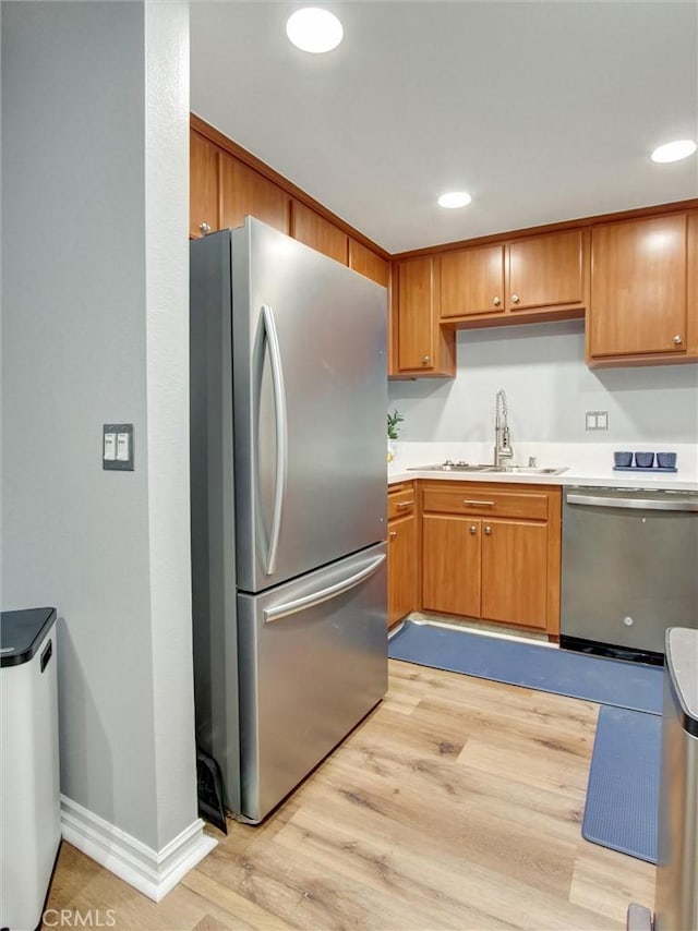 3010 Associated Rd Unit 133, Fullerton, CA 92835 - kitchen with stainless steel appliances, light wood finished floors, light countertops, brown cabinetry, and recessed lighting