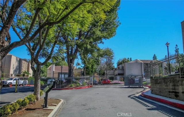 3010 Associated Rd Unit 133, Fullerton, CA 92835 - view of asphalt road featuring a gated entry, a gate, curbs, and a residential view