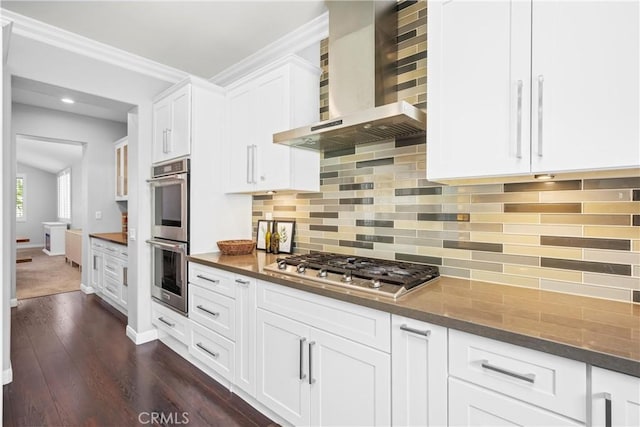 7133 Brisas Ct, Rancho Cucamonga, CA 91739 - kitchen with wall chimney exhaust hood, appliances with stainless steel finishes, dark wood-type flooring, white cabinets, and decorative backsplash