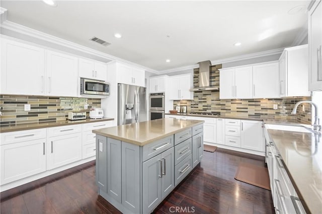 7133 Brisas Ct, Rancho Cucamonga, CA 91739 - kitchen featuring stainless steel appliances, wall chimney range hood, gray cabinets, white cabinetry, and ornamental molding
