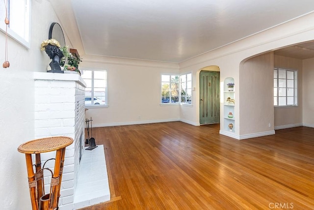 1417 Highland Ave, Needles, CA 92363 - living room with wood finished floors, arched walkways, and a fireplace