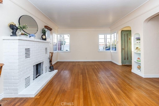1417 Highland Ave, Needles, CA 92363 - unfurnished living room with wood finished floors, a fireplace, healthy amount of natural light, and crown molding