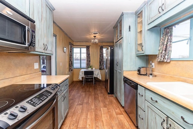 1417 Highland Ave, Needles, CA 92363 - kitchen with appliances with stainless steel finishes, light countertops, light wood-type flooring, and glass insert cabinets