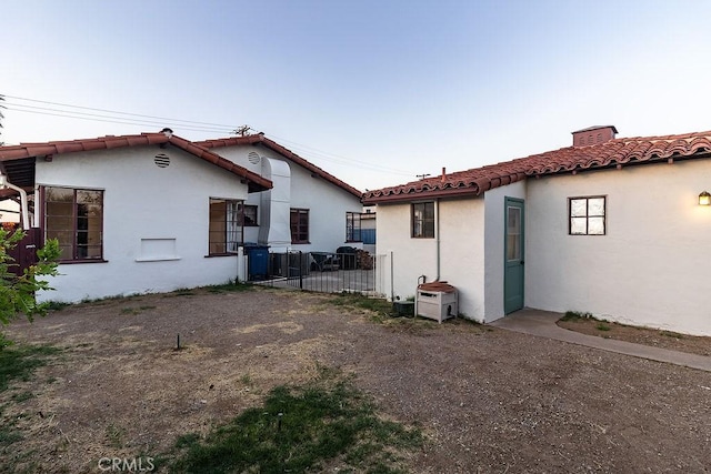 1417 Highland Ave, Needles, CA 92363 - back of house featuring stucco siding, a tiled roof, and a gate