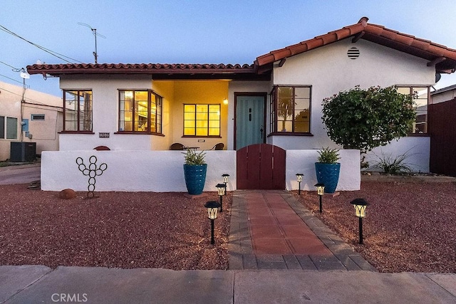 1417 Highland Ave, Needles, CA 92363 - mediterranean / spanish-style home featuring a tile roof, stucco siding, and a gate