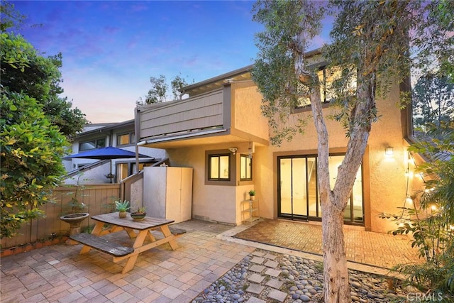 1696 Shady Brook Dr Unit 14, Fullerton, CA 92831 - back of house at dusk with stucco siding and a patio