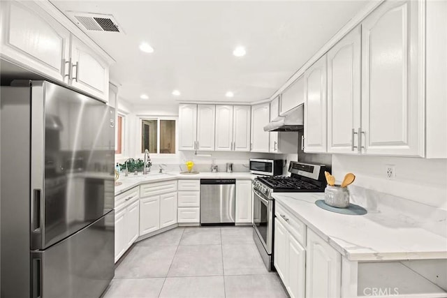 1696 Shady Brook Dr Unit 14, Fullerton, CA 92831 - kitchen with stainless steel appliances, under cabinet range hood, white cabinetry, light tile patterned floors, and recessed lighting