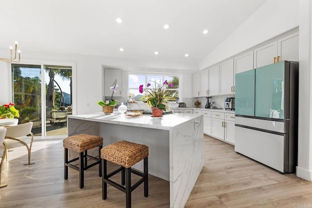 2027 Jenna Pl, Escondido, CA 92029 - kitchen featuring freestanding refrigerator, light stone counters, recessed lighting, a center island, and a breakfast bar area