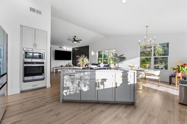 2027 Jenna Pl, Escondido, CA 92029 - kitchen with appliances with stainless steel finishes, gray cabinetry, lofted ceiling, light wood-type flooring, and a center island