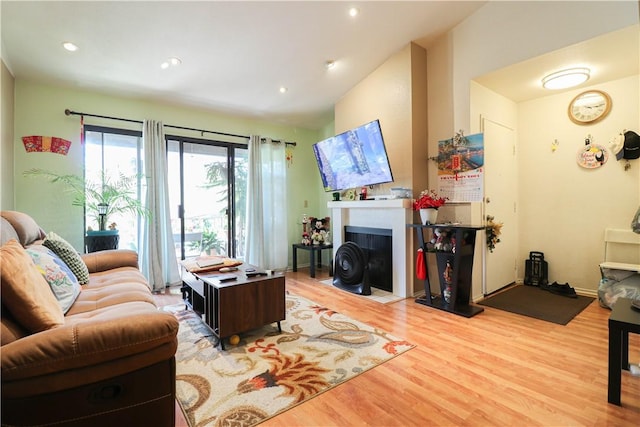 13135 Sunnybrook Cir Unit 205, Garden Grove, CA 92844 - living area featuring light wood finished floors, a fireplace with flush hearth, recessed lighting, and vaulted ceiling