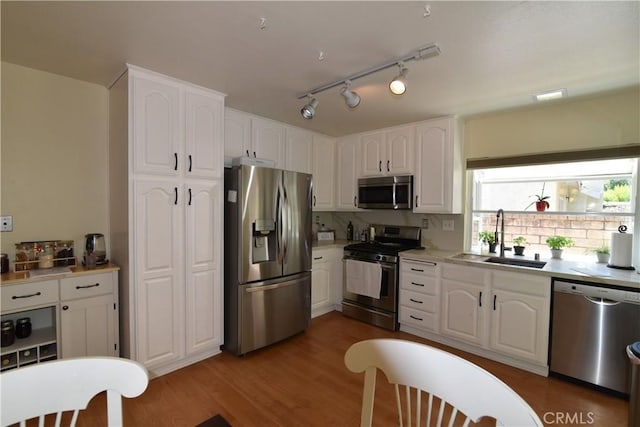 20611 Alaminos Dr, Saugus, CA 91350 - kitchen featuring appliances with stainless steel finishes, white cabinetry, light countertops, and dark wood-type flooring