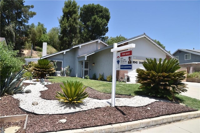20611 Alaminos Dr, Saugus, CA 91350 - view of front of house featuring a garage, a front lawn, stucco siding, and concrete driveway