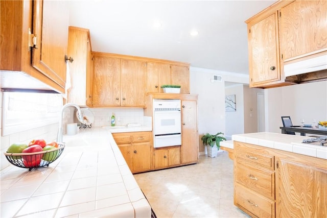 3730 E Euclid Ave, Orange, CA 92869 - kitchen featuring tile countertops, white oven, a warming drawer, backsplash, and light brown cabinets