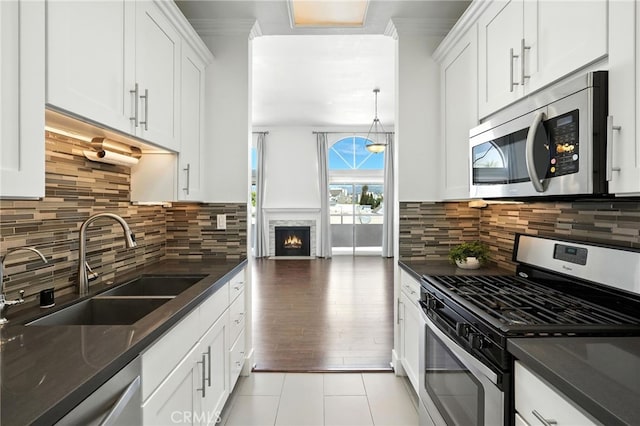 12001 Goshen Ave Unit 303, Los Angeles, CA 90049 - kitchen with appliances with stainless steel finishes, white cabinets, backsplash, and crown molding