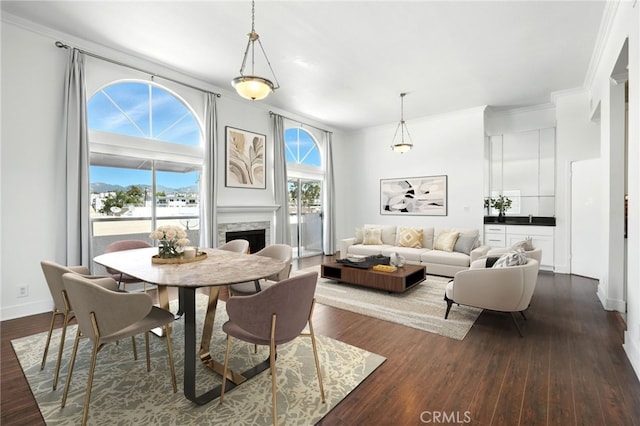 12001 Goshen Ave Unit 303, Los Angeles, CA 90049 - dining space featuring ornamental molding, dark wood-style floors, and a fireplace