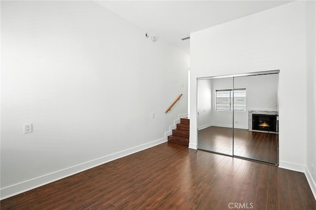 12001 Goshen Ave Unit 303, Los Angeles, CA 90049 - unfurnished living room with stairs, wood finished floors, and a lit fireplace