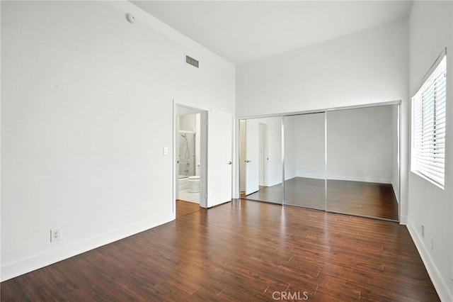 12001 Goshen Ave Unit 303, Los Angeles, CA 90049 - unfurnished bedroom featuring a towering ceiling, wood finished floors, a closet, and ensuite bathroom