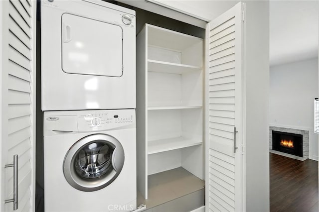 12001 Goshen Ave Unit 303, Los Angeles, CA 90049 - laundry area featuring stacked washer / dryer, wood finished floors, and a lit fireplace