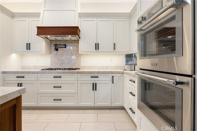 2666 Peacock Pl, La Verne, CA 91750 - kitchen featuring stainless steel appliances, backsplash, light tile patterned floors, white cabinetry, and light stone counters