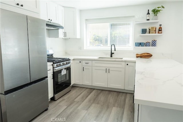 41 Scottsdale S, Carson, CA 90745 - kitchen featuring appliances with stainless steel finishes, under cabinet range hood, white cabinetry, light wood-type flooring, and open shelves
