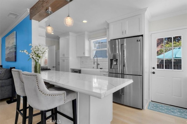 5535 W 142nd Pl, Hawthorne, CA 90250 - kitchen with stainless steel fridge with ice dispenser, ornamental molding, white cabinetry, backsplash, and a breakfast bar