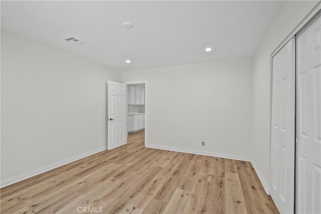 8558 W W Ave E8, Lancaster, CA 93536 - unfurnished bedroom with light wood finished floors, recessed lighting, and a closet