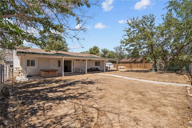 8558 W W Ave E8, Lancaster, CA 93536 - back of property featuring a jacuzzi, a fenced backyard, stucco siding, and a patio area
