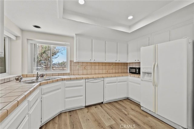 8558 W W Ave E8, Lancaster, CA 93536 - kitchen with white appliances, light wood-style flooring, white cabinets, backsplash, and recessed lighting