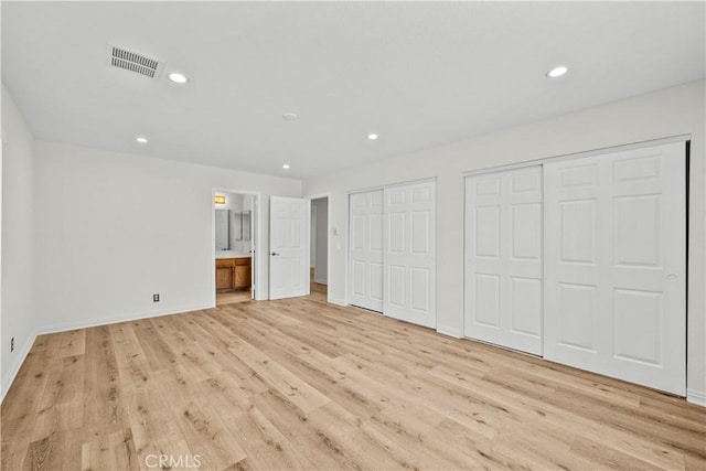 8558 W W Ave E8, Lancaster, CA 93536 - unfurnished bedroom with two closets, light wood-style flooring, recessed lighting, and connected bathroom