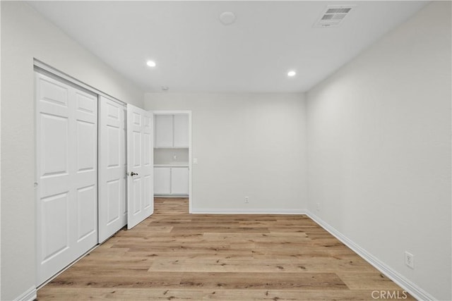 8558 W W Ave E8, Lancaster, CA 93536 - unfurnished bedroom with recessed lighting, light wood-type flooring, and a closet