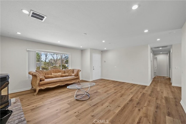 8558 W W Ave E8, Lancaster, CA 93536 - living room featuring a wood stove, light wood-type flooring, and recessed lighting