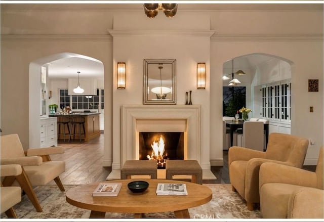 4730 Angeles Vista Blvd, View Park, CA 90043 - living room with wood finished floors, arched walkways, ornamental molding, and a lit fireplace