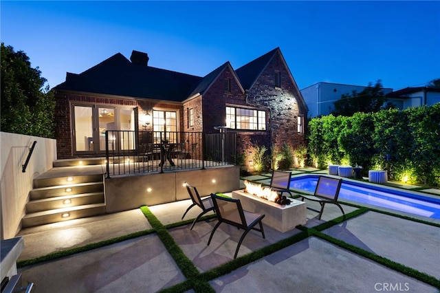 4730 Angeles Vista Blvd, View Park, CA 90043 - rear view of house with an outdoor fire pit, a patio area, brick siding, and a chimney