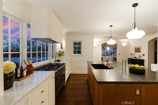 4730 Angeles Vista Blvd, View Park, CA 90043 - kitchen featuring exhaust hood, double oven range, arched walkways, dark wood-type flooring, and brown cabinets