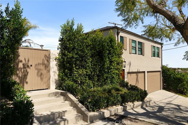 4730 Angeles Vista Blvd, View Park, CA 90043 - view of front of house with stucco siding, a garage, and concrete driveway