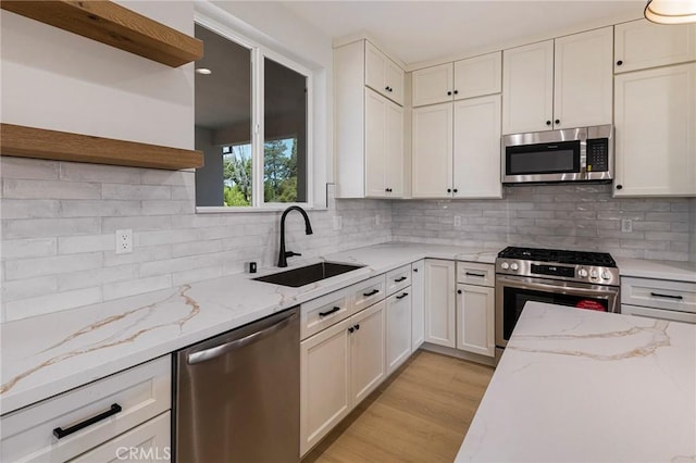5909 Del Mar Ave, Paradise, CA 95969 - kitchen featuring stainless steel appliances, open shelves, decorative backsplash, and light wood-type flooring