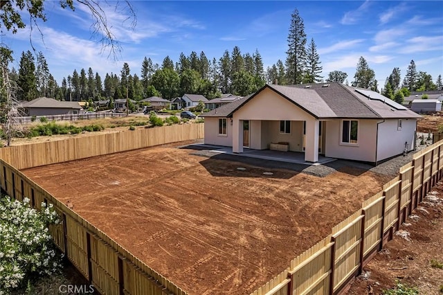 5909 Del Mar Ave, Paradise, CA 95969 - back of property featuring a patio, a fenced backyard, roof mounted solar panels, stucco siding, and roof with shingles