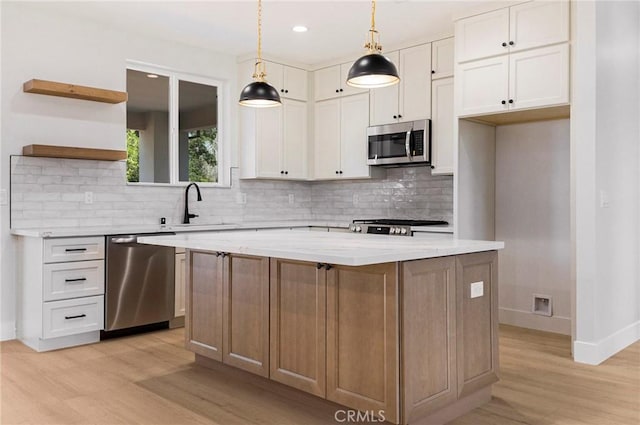 5909 Del Mar Ave, Paradise, CA 95969 - kitchen featuring appliances with stainless steel finishes, light wood-style flooring, open shelves, backsplash, and a center island