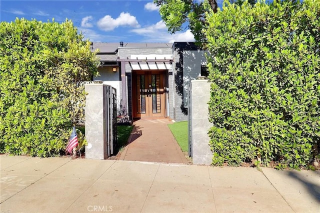 182 Denslow Ave, Los Angeles, CA 90049 - view of front of property featuring roof mounted solar panels, a fenced front yard, a gate, and stucco siding