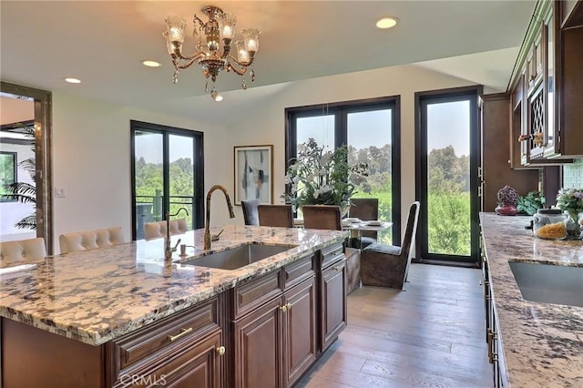 182 Denslow Ave, Los Angeles, CA 90049 - kitchen with recessed lighting, a chandelier, light stone counters, a center island with sink, and light wood-style floors