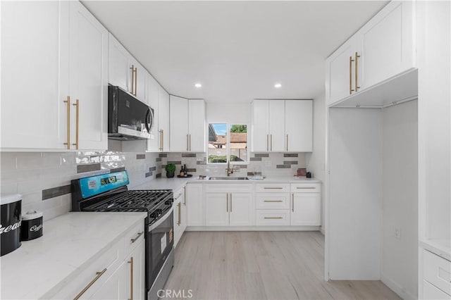 611 Griffith St, San Fernando, CA 91340 - kitchen featuring stainless steel range with gas cooktop, light wood finished floors, white cabinetry, and recessed lighting
