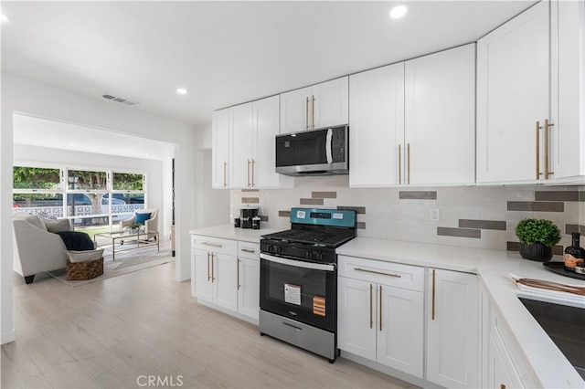 611 Griffith St, San Fernando, CA 91340 - kitchen featuring stainless steel appliances, white cabinets, backsplash, recessed lighting, and light countertops