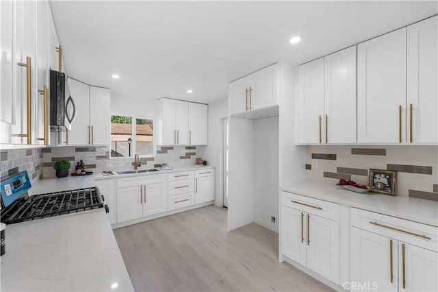 611 Griffith St, San Fernando, CA 91340 - kitchen with appliances with stainless steel finishes, tasteful backsplash, light stone countertops, white cabinetry, and recessed lighting