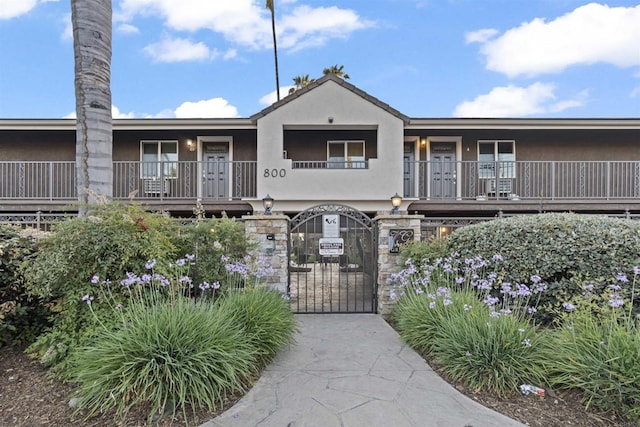 800 N Mollison Ave Unit 56, El Cajon, CA 92021 - view of front of property with a gate, stucco siding, a balcony, and a fenced front yard