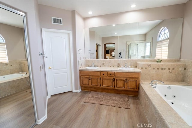 39560 Tinderbox Way, Murrieta, CA 92562 - bathroom featuring double vanity, wood finished floors, and a tub with jets