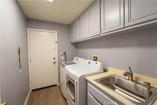 39560 Tinderbox Way, Murrieta, CA 92562 - washroom with independent washer and dryer, cabinet space, and light wood-style flooring