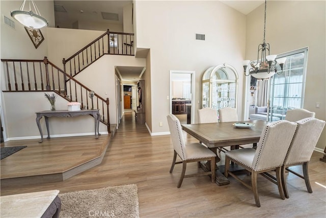 39560 Tinderbox Way, Murrieta, CA 92562 - dining area with a chandelier, wood finished floors, a towering ceiling, and stairs